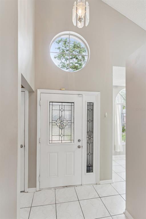 A bright entryway features a white front door with decorative glass, tile flooring, and a window — 4017 QUAIL BRIAR DRIVE, VALRICO, FL