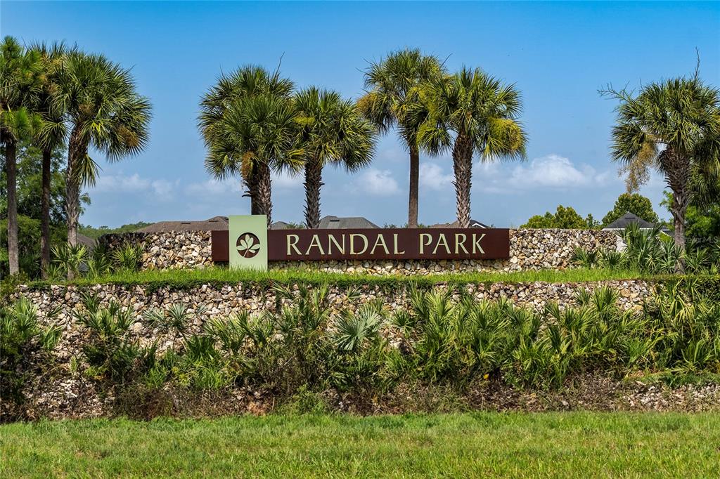 A row of three attached townhomes with gray siding, stone accents, and front porches — 8515 VEDDER LN, ORLANDO, FL