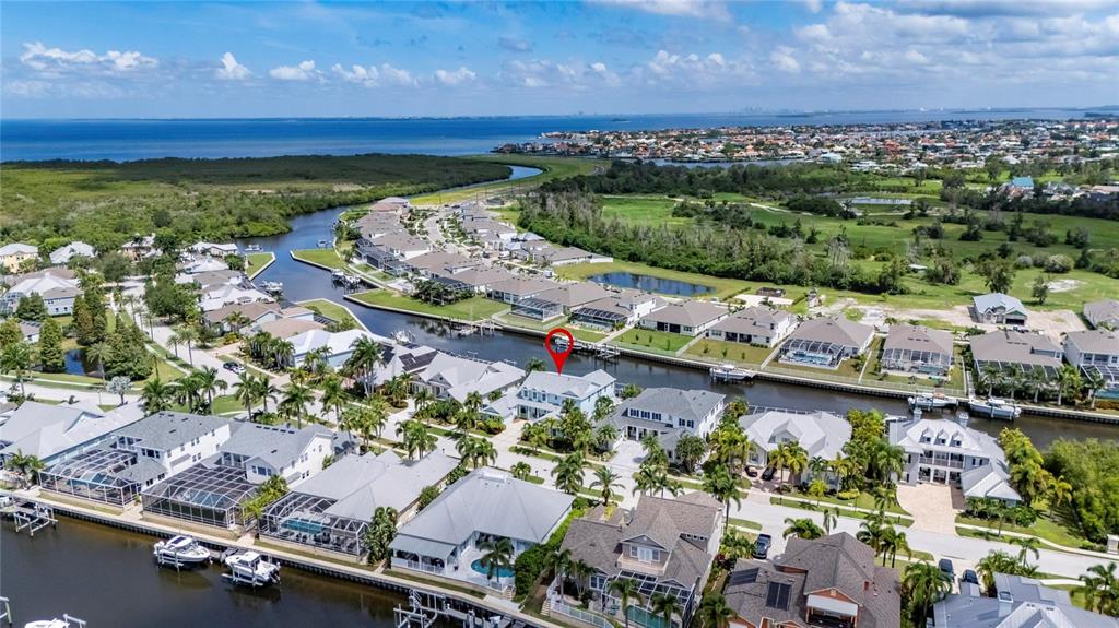 An aerial view shows a waterfront residential neighborhood with houses along a canal — 715 ISLEBAY DRIVE, APOLLO BEACH, FL