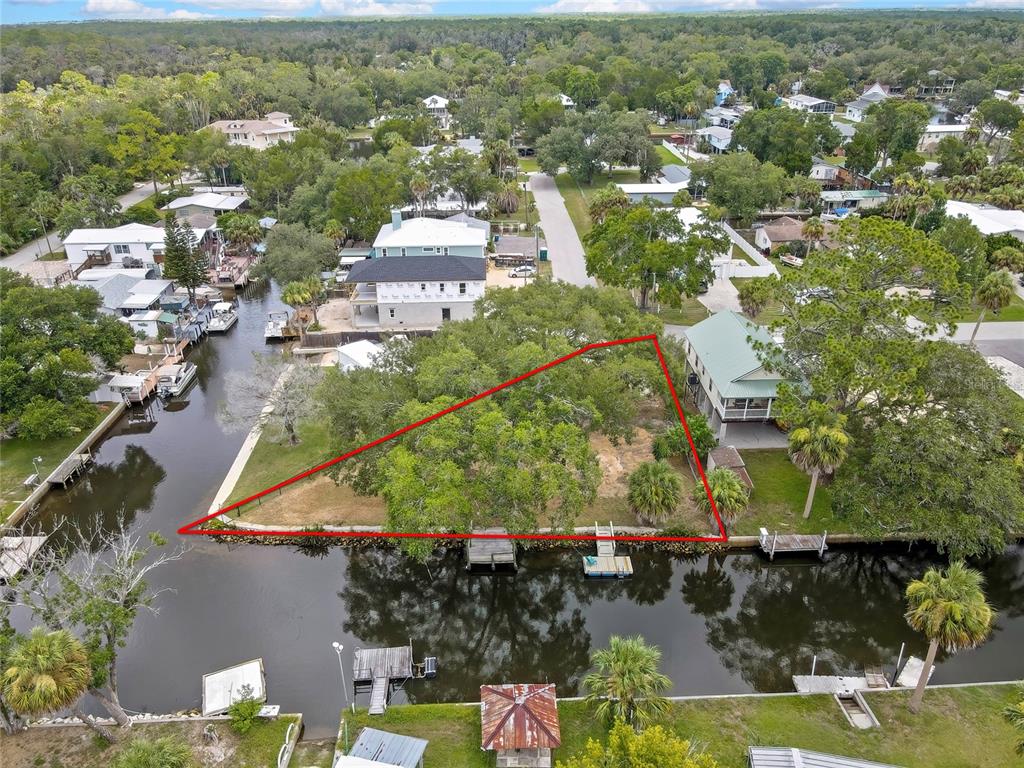 An aerial view shows a waterfront lot outlined in red with mature trees and docks — 6134 ISLAND DRIVE, WEEKI WACHEE, FL