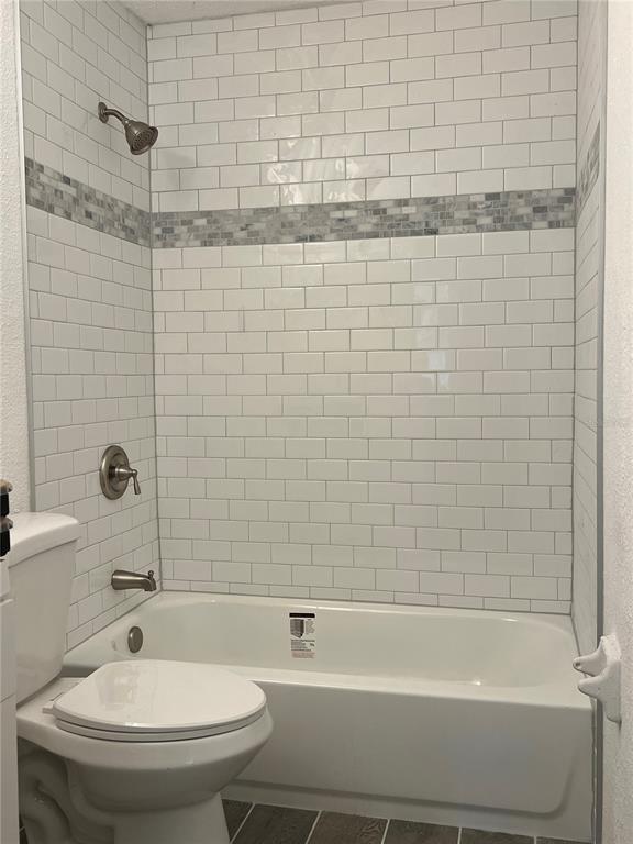 A bathroom features a white subway tile shower surround with a decorative mosaic accent strip — 2075 DIXIE AVENUE, SANFORD, FL