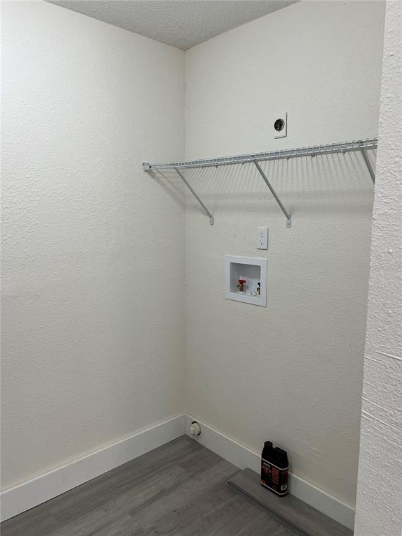 A laundry closet with a wire shelf, plumbing hookups, and light gray wood-look flooring — 2075 DIXIE AVENUE, SANFORD, FL