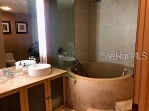 A bathroom features a circular soaking tub, a glass shower enclosure, and a vessel sink vanity — 101 PALM HARBOR PARKWAY UNIT A-308B, PALM COAST, FL