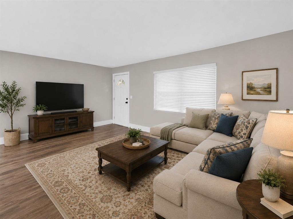 A living room features a beige sectional sofa, a wooden coffee table, and a television console — 61 S TYLER STREET, BEVERLY HILLS, FL