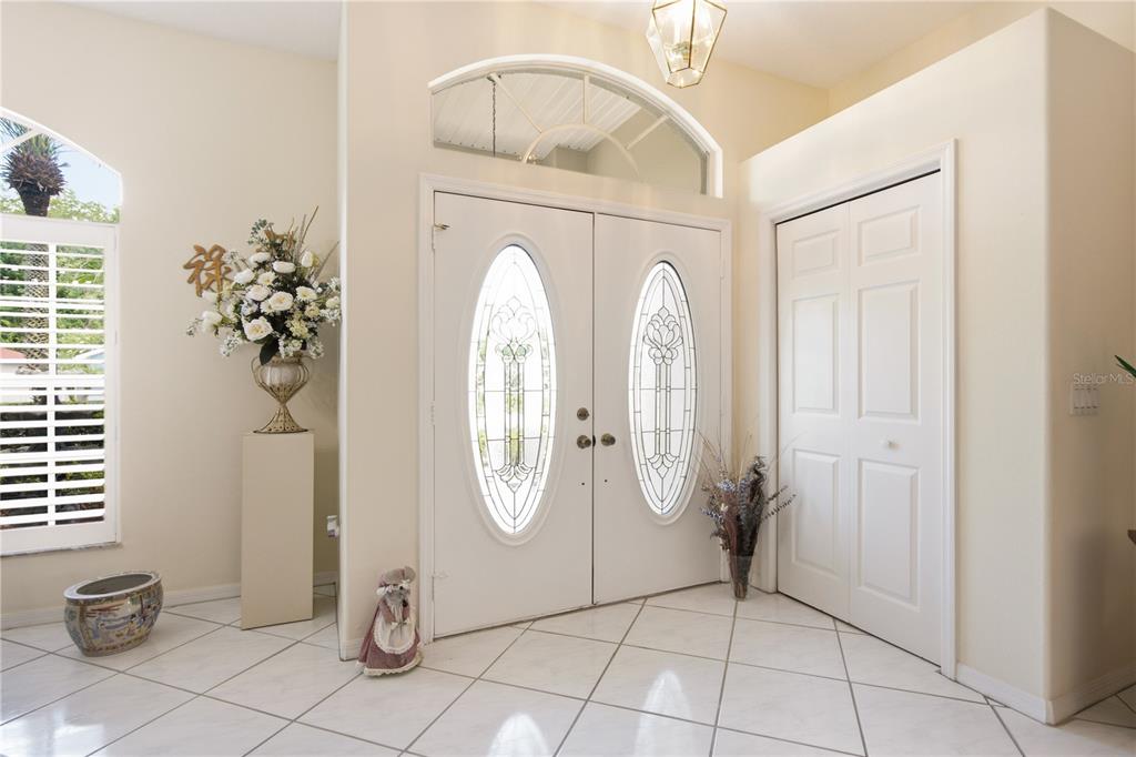 An entryway features white double doors with glass inserts, tiled floors, and a closet — 8704 CYPRESS LAKES BOULEVARD, NEW PORT RICHEY, FL