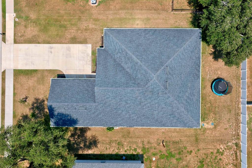 An aerial view shows a house with a dark shingled roof, a driveway, and yard — 1415 MAGNOLIA LANE, AUBURNDALE, FL