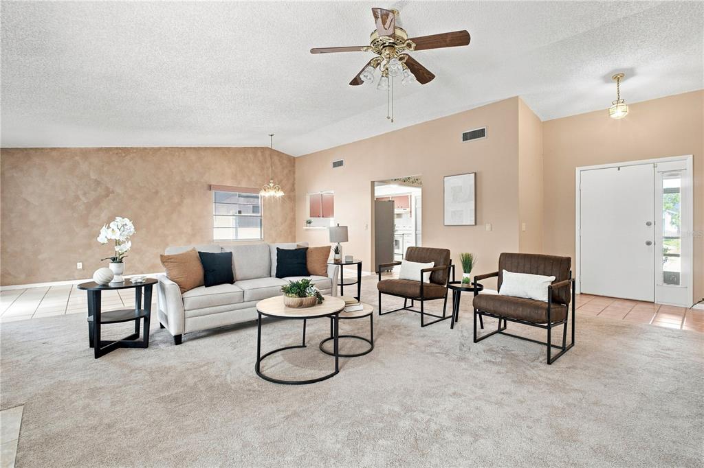 A living room features a beige sofa, two brown armchairs, and a ceiling fan — 6803 LONGPOINTE WAY, TAMPA, FL