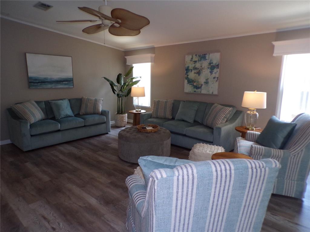 A living room features two blue sofas, two striped armchairs, and a round ottoman — 232 NATURES WAY, NORTH PORT, FL