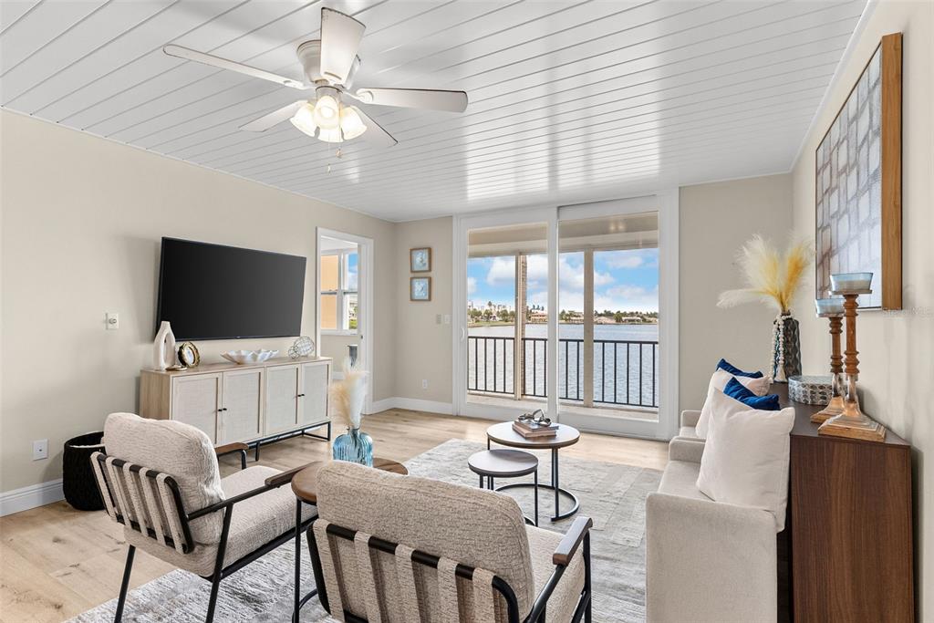 A kitchen with white cabinets, marble countertops, and a view of the water through sliding doors — 7920 SUN ISLAND DRIVE S UNIT 202, SOUTH PASADENA, FL