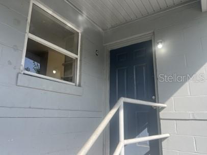A dark blue front door and a window are set into a light gray exterior wall — 543 DIVISION STREET UNIT 4, DAYTONA BEACH, FL