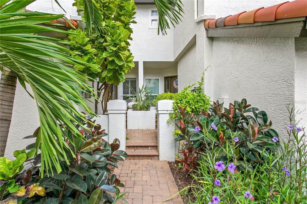 A brick walkway leads to the front entrance of a home with lush landscaping — 1116 SHIPWATCH CIRCLE, TAMPA, FL