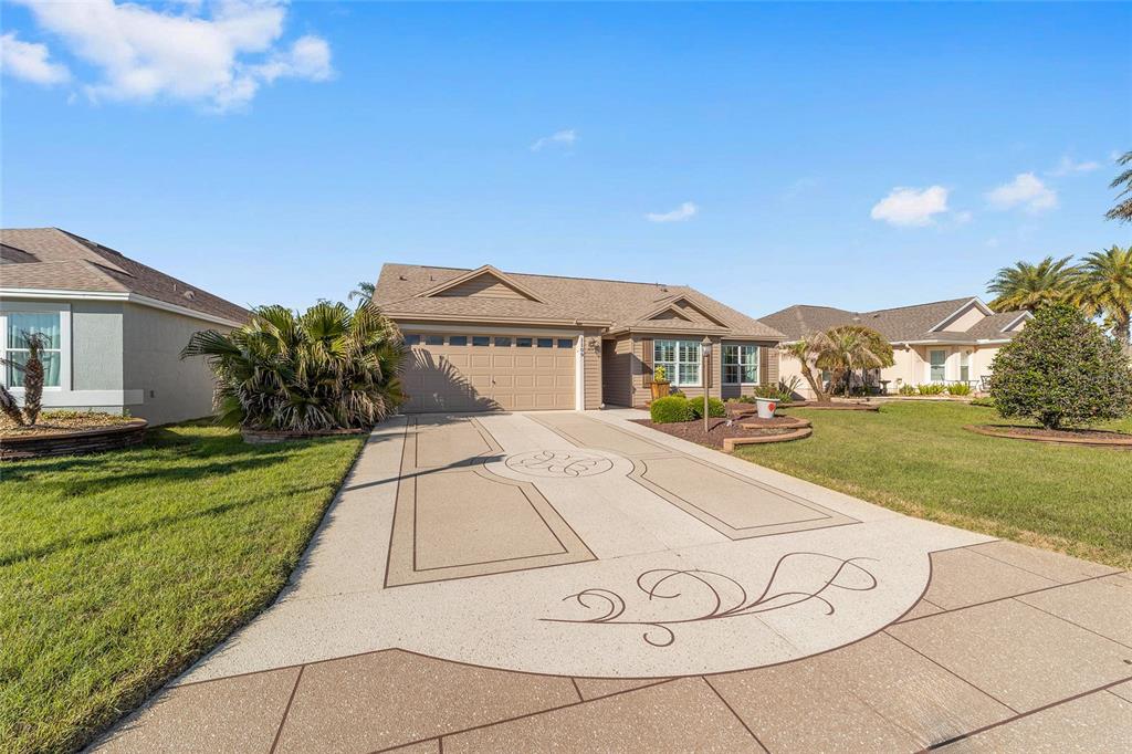 An open-concept living room and kitchen featuring tile floors, a ceiling fan, and sliding doors — 1109 ALCOVE LOOP, THE VILLAGES, FL