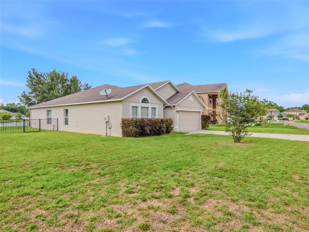 A single-story suburban house with a tan stucco exterior, a garage, and a large lawn — 7357 CUMBRIA BOULEVARD, JACKSONVILLE, FL