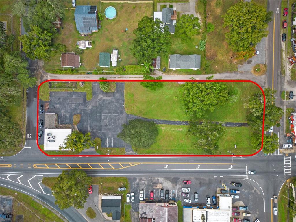 An aerial view shows a rectangular lot with a paved parking area and a building — 4917 GALL BOULEVARD, ZEPHYRHILLS, FL