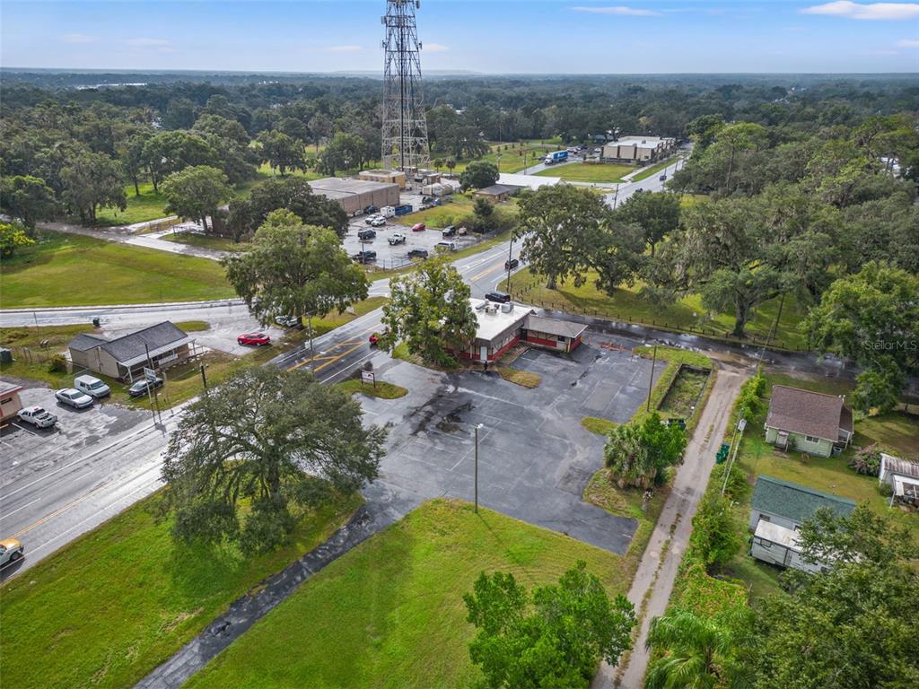 An aerial view shows a commercial building with a parking lot near a road intersection — 4917 GALL BOULEVARD, ZEPHYRHILLS, FL