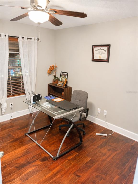 A home office features a glass desk, a gray chair, and a diploma on the wall — 2927 CURVING OAKS WAY, ORLANDO, FL