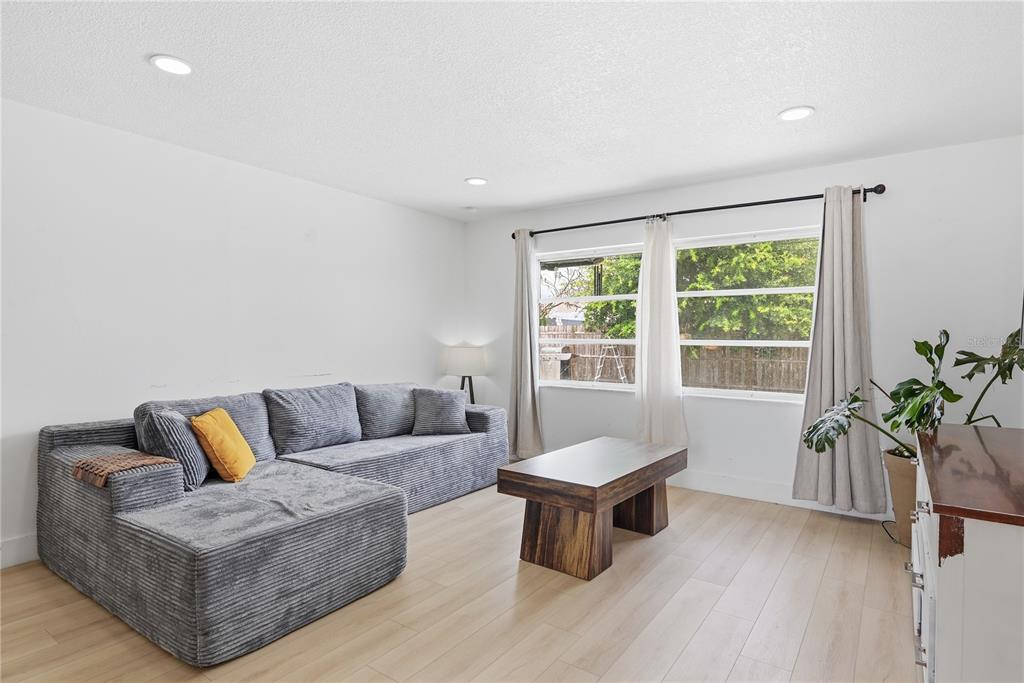 A living room features a gray sectional sofa, a wooden coffee table, and light wood flooring — 835 MARLOWE AVENUE, ORLANDO, FL
