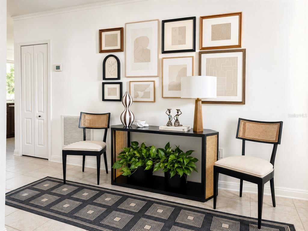 A console table with plants and chairs sits against a wall with a gallery display — 30875 PARROT REEF, WESLEY CHAPEL, FL