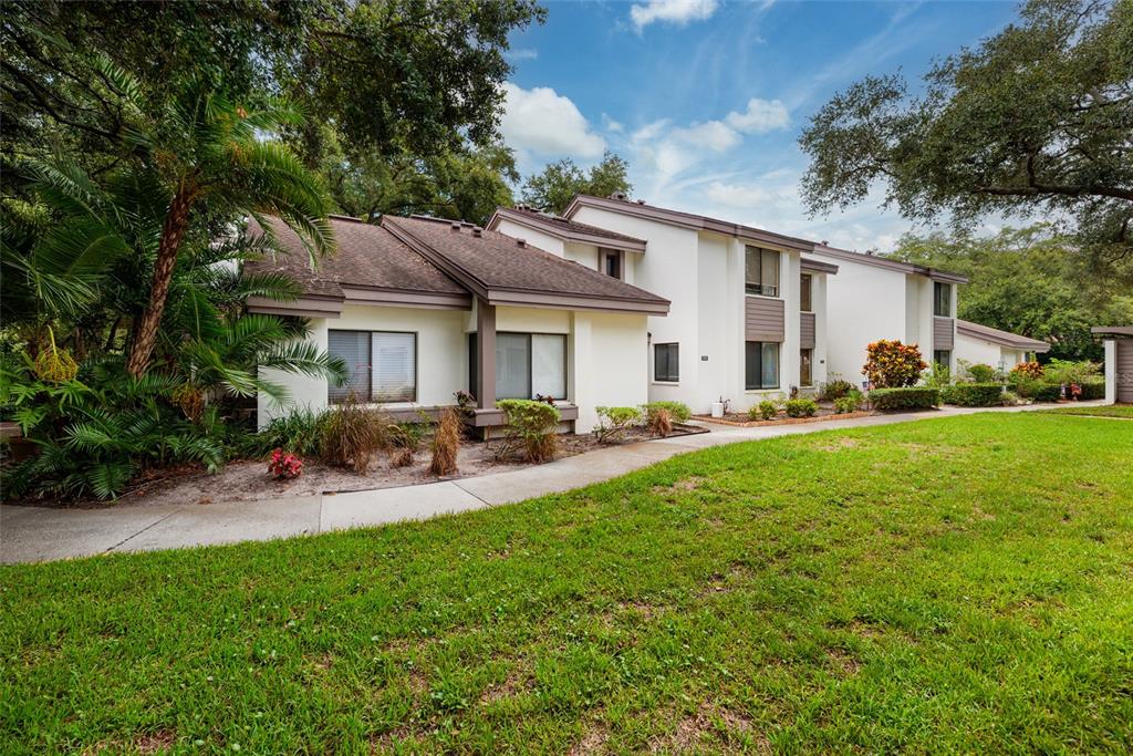 The exterior of a two-story home features a brick walkway leading to a recessed entrance — 1750 LAKE CYPRESS DRIVE UNIT 1002, SAFETY HARBOR, FL