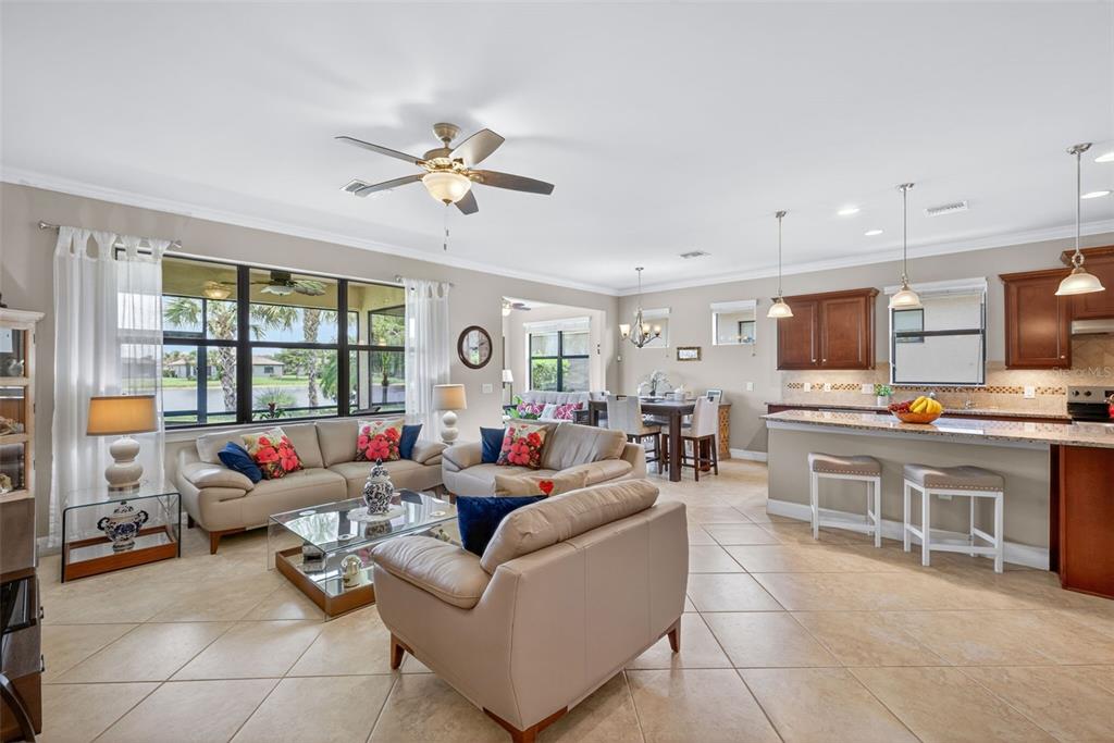 An open-concept living room and kitchen feature tile flooring, neutral walls, and large windows — 5979 PROSPERITY LANE, IMMOKALEE, FL