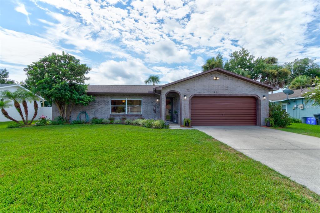 A single-story brick house with a brown garage door and a large front lawn — 16 LAUREL OAKS CIRCLE, ORMOND BEACH, FL
