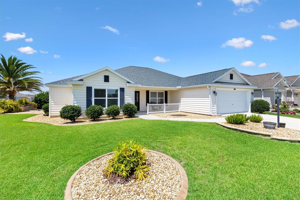 A single-story house with light siding, a shingled roof, and a manicured front lawn — 3602 PEPPERIDGE CIRCLE, THE VILLAGES, FL