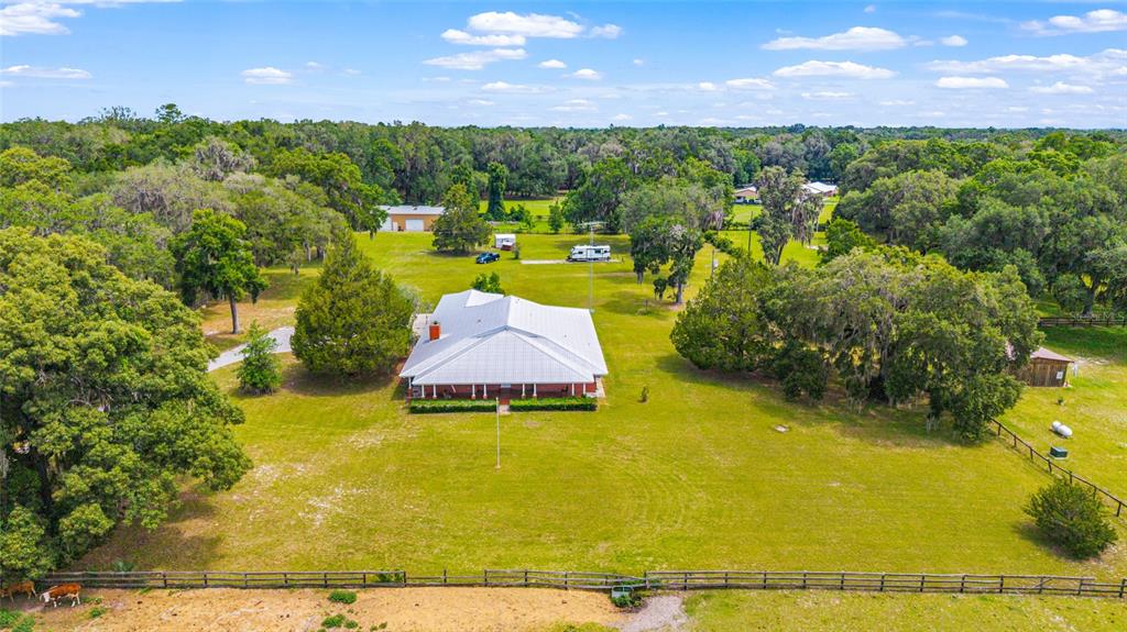 An aerial view shows a single-story house with a metal roof on a large lot — 2285 W HIGHWAY 318, CITRA, FL