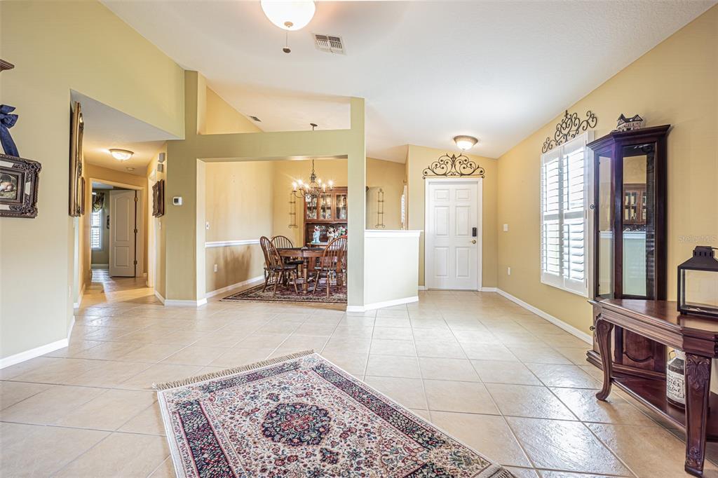 A tiled entryway leads to a dining area with a chandelier and a front door — 29435 SNAP HOOK DRIVE, SAN ANTONIO, FL