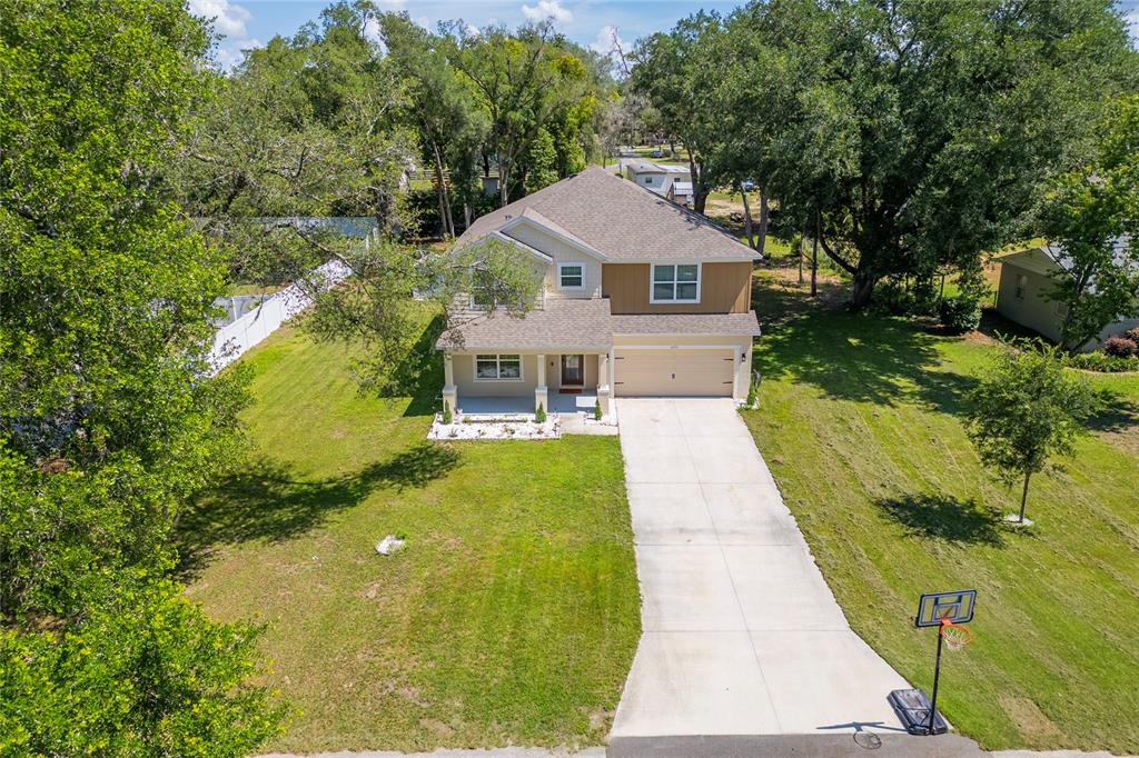 An aerial view shows a two-story house with a concrete driveway and a basketball hoop — 4331 WAYNE ROAD, FRUITLAND PARK, FL