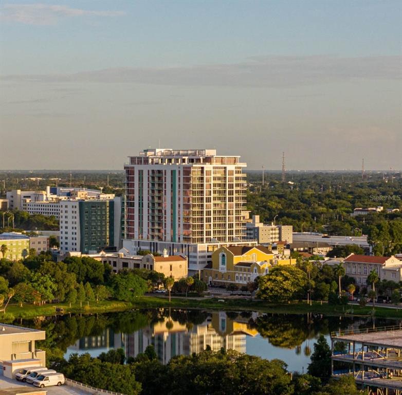 An aerial view of a tall apartment building overlooking a lake and surrounding city landscape — 777 3RD AVENUE N UNIT 1605, ST PETERSBURG, FL