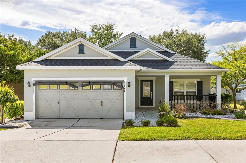A single-story house with a two-car garage, light gray siding, and a covered front porch — 20934 SULLIVAN RANCH BOULEVARD, MOUNT DORA, FL