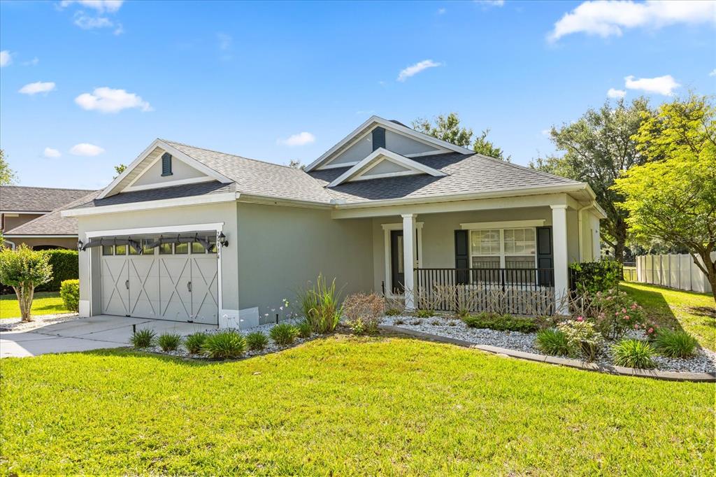A single-story house with a gray exterior, a two-car garage, and a covered front porch — 20934 SULLIVAN RANCH BOULEVARD, MOUNT DORA, FL