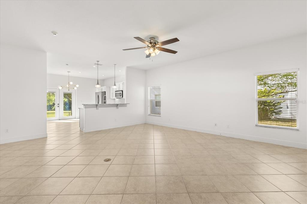 An open-concept living area with tile flooring, a ceiling fan, and a kitchen island — 20934 SULLIVAN RANCH BOULEVARD, MOUNT DORA, FL