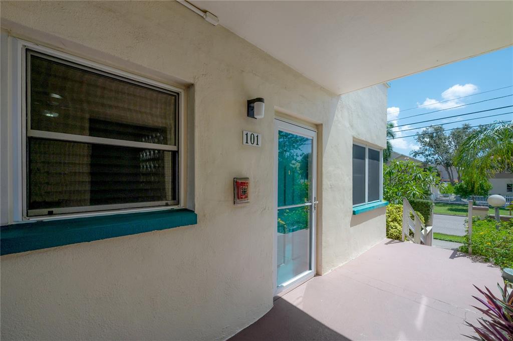 An exterior view of a building entrance with a door labeled 101 and a porch — 2960 59TH STREET S UNIT 101, GULFPORT, FL