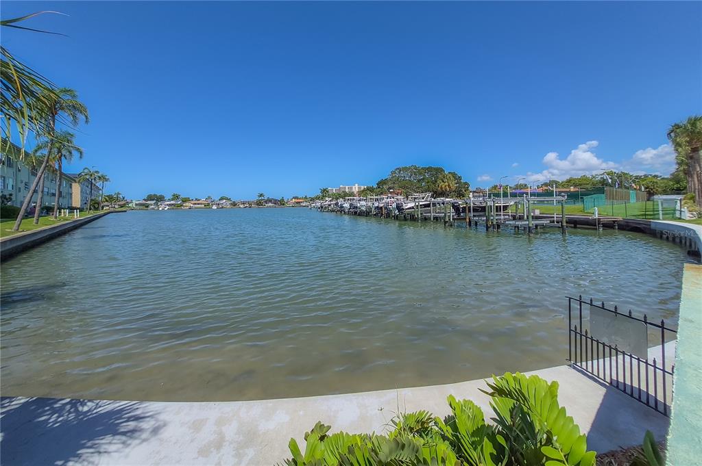 A view of a calm canal with boat docks and residential buildings in the background — 2960 59TH STREET S UNIT 101, GULFPORT, FL