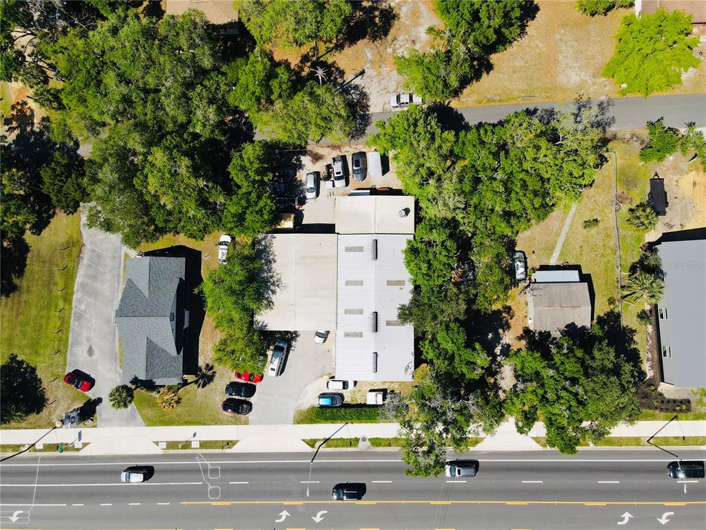 An aerial view shows a commercial building with a parking lot surrounded by trees — 853 NE 5TH STREET, CRYSTAL RIVER, FL