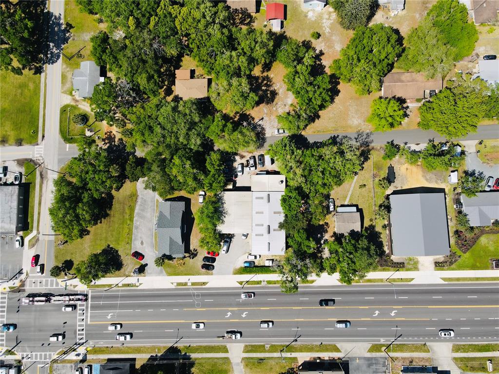 Aerial view of a commercial property with a parking lot located next to a highway — 853 NE 5TH STREET, CRYSTAL RIVER, FL