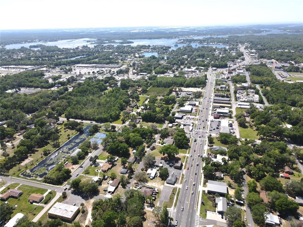 Aerial view of a town with a main road, surrounding residential areas, and nearby lakes — 853 NE 5TH STREET, CRYSTAL RIVER, FL
