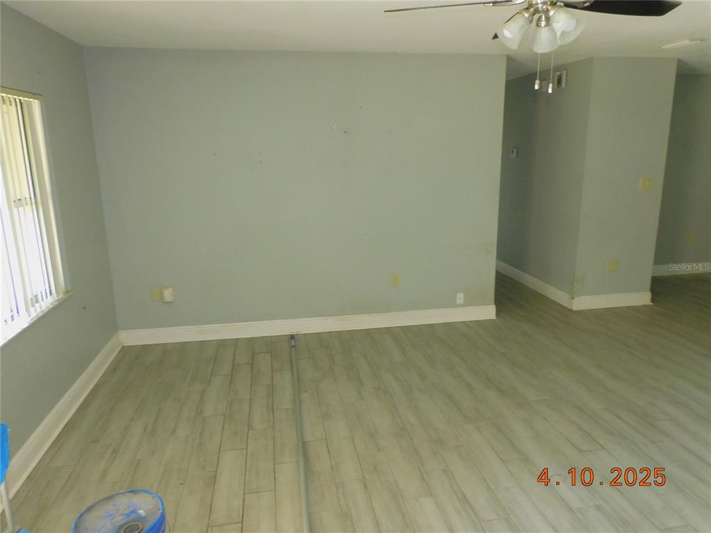 An empty room features light gray walls, wood-look tile flooring, and a ceiling fan — 436 MICHIGAN AVENUE, ST CLOUD, FL