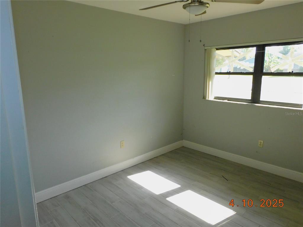 An empty bedroom features light gray walls, wood-look tile flooring, and a ceiling fan — 436 MICHIGAN AVENUE, ST CLOUD, FL