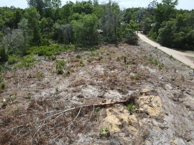 An aerial view of a cleared, sandy residential lot bordered by trees and a road — X SE 143RD LN, UMATILLA, FL