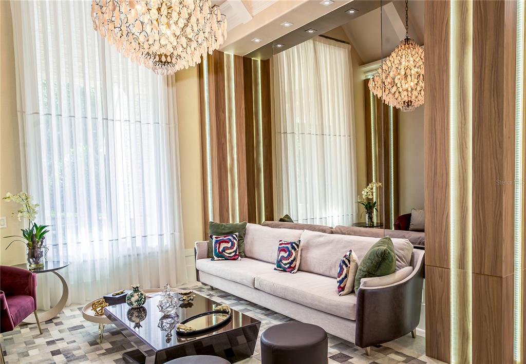 A living room features a light-colored sofa, a dark coffee table, and two crystal chandeliers — 6719 VALHALLA WAY, WINDERMERE, FL