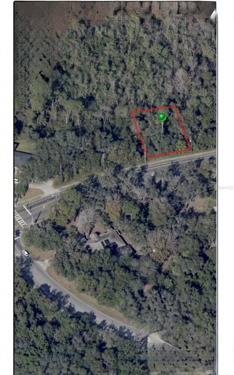 An aerial view shows a wooded lot outlined in red with a green location marker — 1778 E NORMANDY BOULEVARD, DELTONA, FL