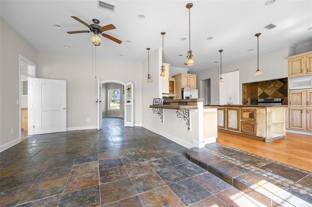 A kitchen and dining area with slate tile flooring, a breakfast bar, and wooden cabinetry — 10852 89TH ROAD, LIVE OAK, FL