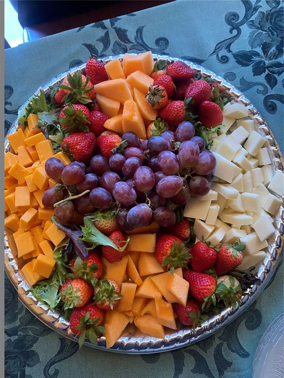 A silver platter is filled with cubed cheddar cheese, white cheese, strawberries, and cantaloupe — 883 WEST BAY DRIVE, LARGO, FL