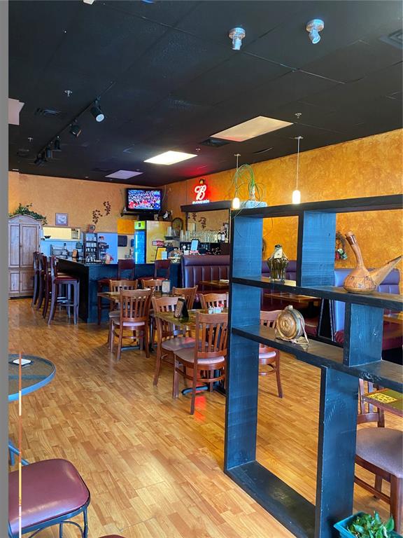 A restaurant interior features wooden flooring, a black ceiling, and a dark wood room divider — 883 WEST BAY DRIVE, LARGO, FL