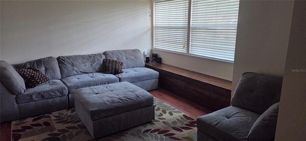 A living room features a grey sectional sofa, a matching ottoman, and a built-in wooden bench — 225 YARMOUTH ROAD, FERN PARK, FL