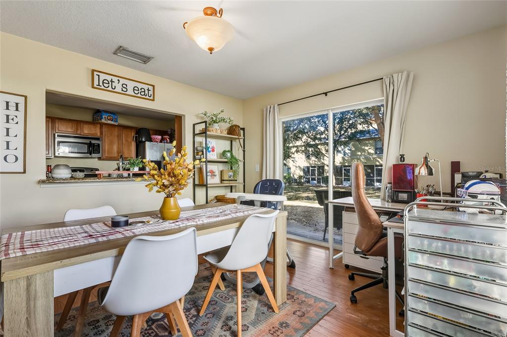 A dining area features a wooden table, white chairs, and an adjacent home office space — 10952 KEYS GATE DRIVE, RIVERVIEW, FL