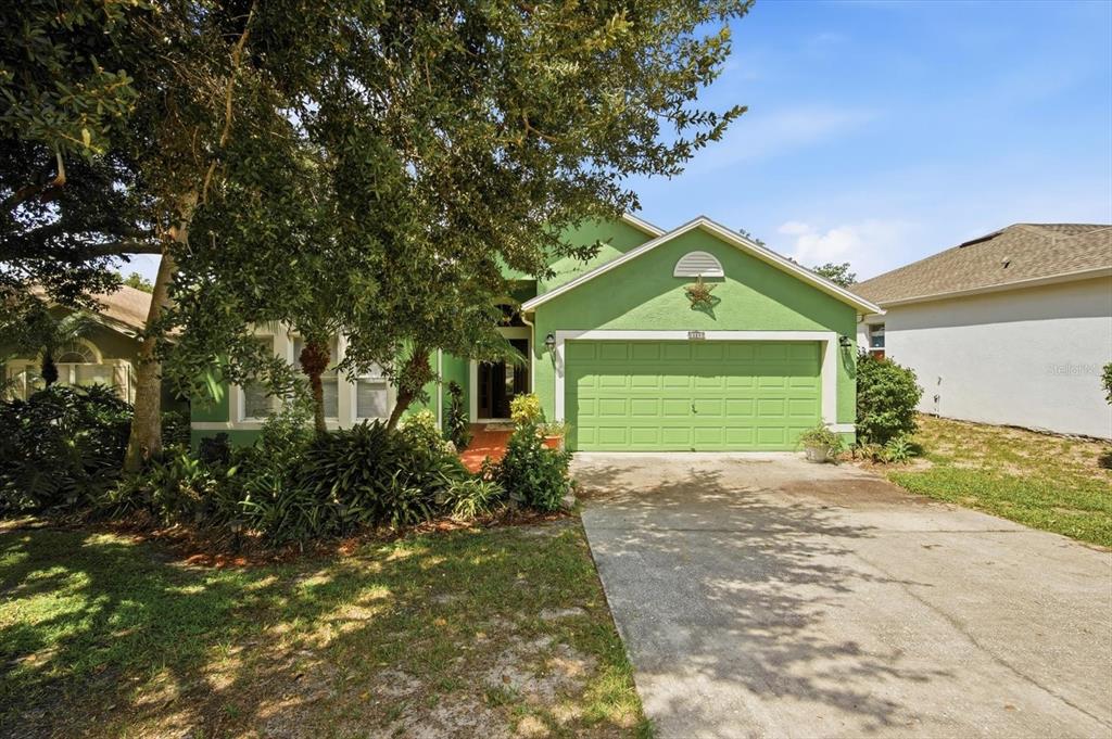 A lime green single-story house with a two-car garage and a concrete driveway — 809 ROCKY MOUNTAIN COURT, VALRICO, FL