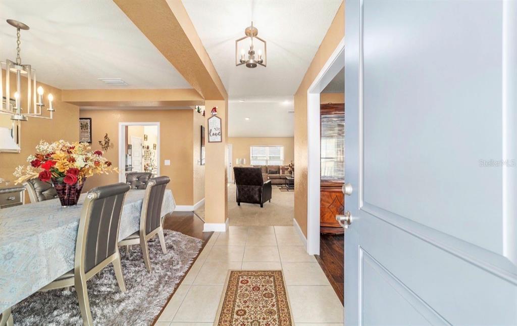 An entryway with tile flooring leads into a dining room and a carpeted living area — 4000 SE 98TH PLACE, BELLEVIEW, FL